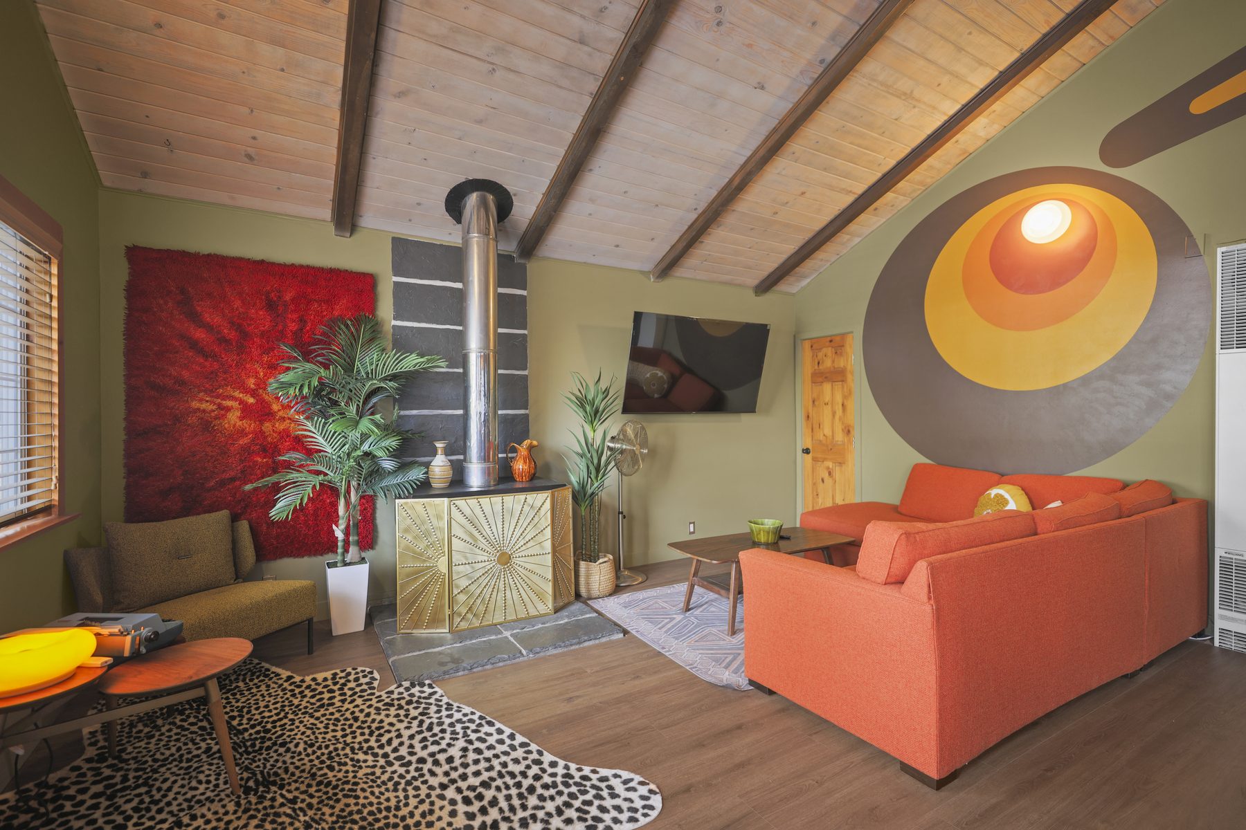 Cabin 99 living room with orange sofa and circle mural